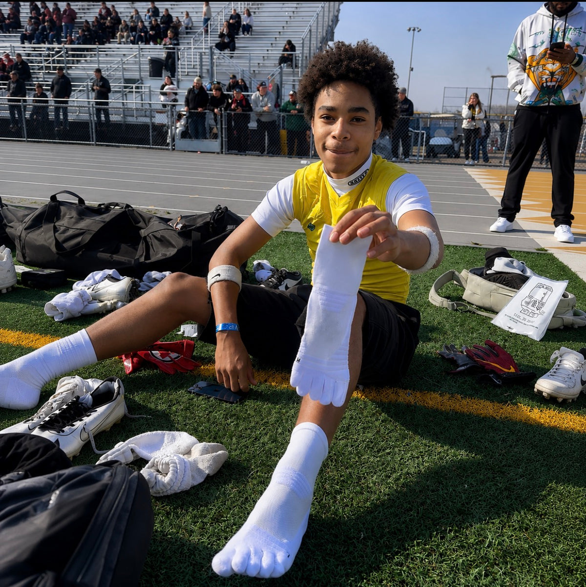 Football player wearing white 1st ERA Performance Toe Socks with five-toe separation before competition