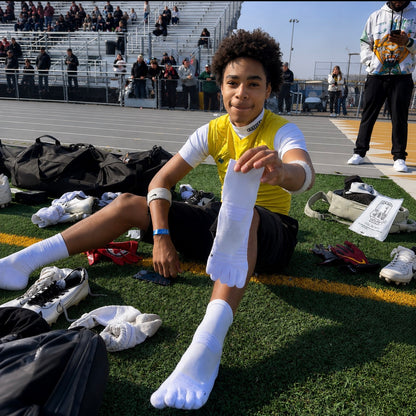 Football player wearing white 1st ERA Performance Toe Socks with five-toe separation before competition