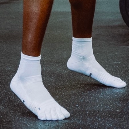 Athlete wearing white 1st ERA Performance Toe Socks with five-toe separation during gym training